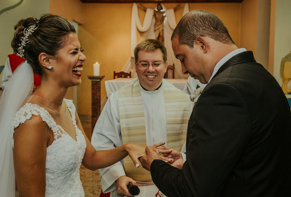 noivo sorri enquanto o noivo coloca a aliança nela cerimonia de casamento fotografo de casamento rj andre nogueira fotografia