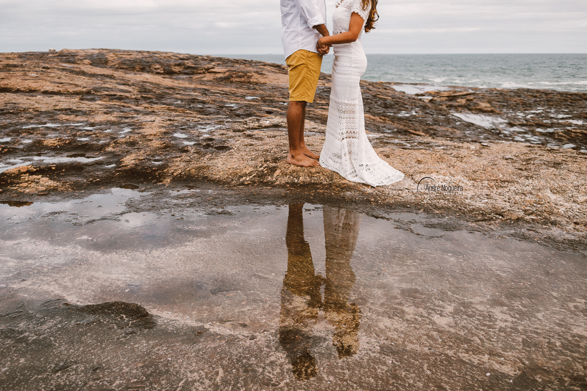 casal de mãos dadas e refletindo na poça d'agua