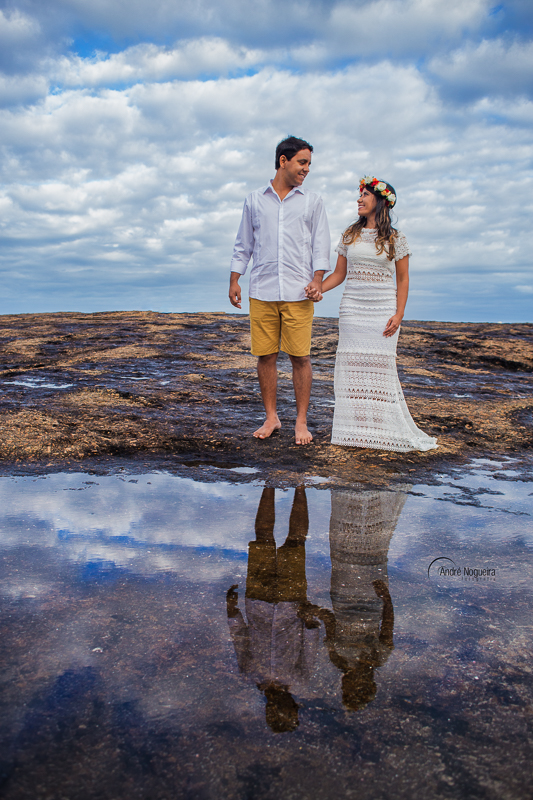 de mãos dadas e refletindo diante da poça d'agua