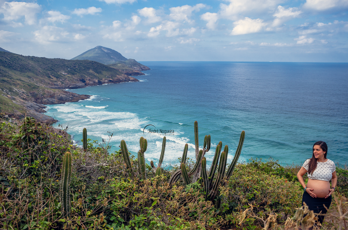 linda gestante numa linda paisagem, com muito verde e um mar azul