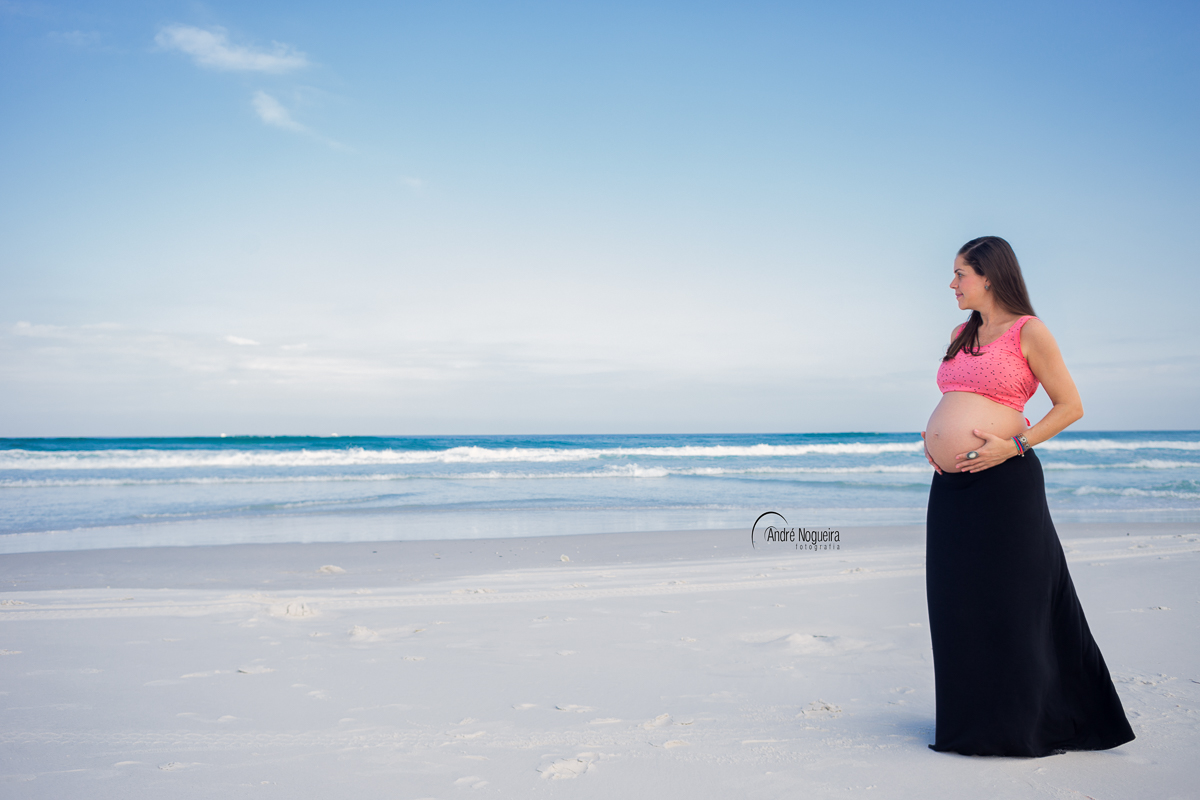 gestante linda contemplando a imensidão do mar azul de arraial de cabo