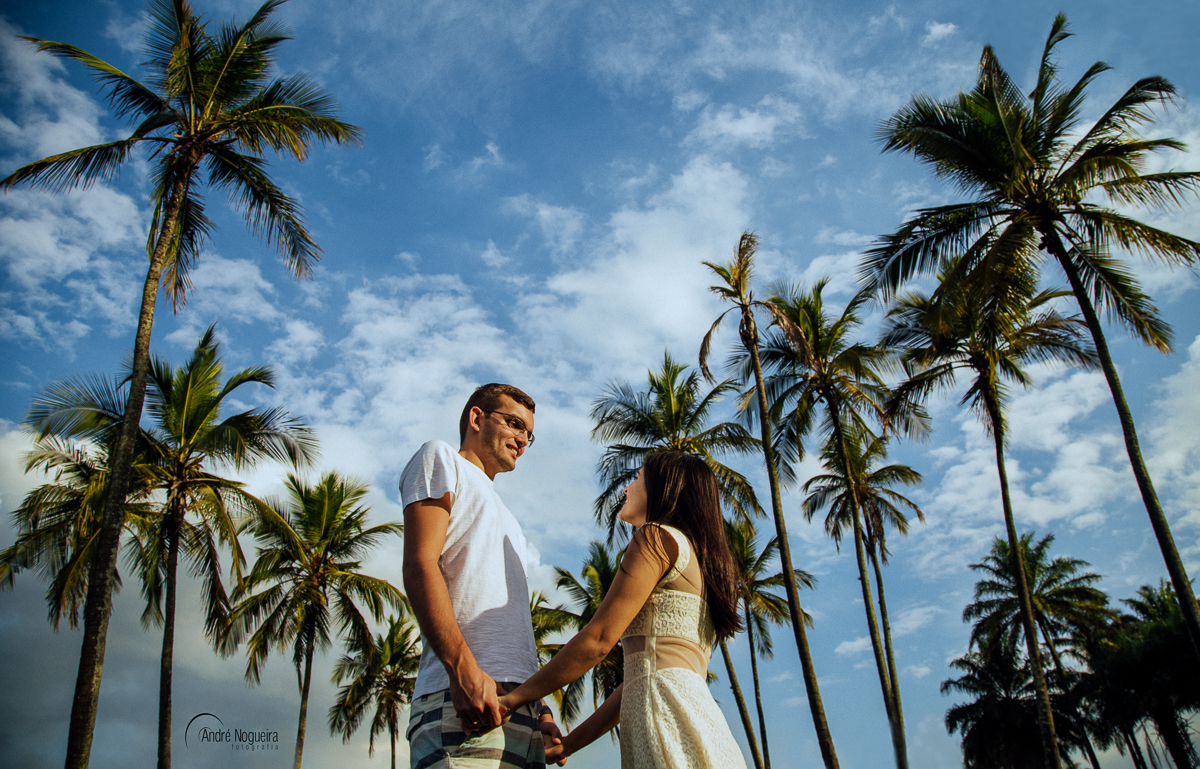 linda cena de um casal se olhando apaixonadamente e emoldurdos por vários coqueiros
