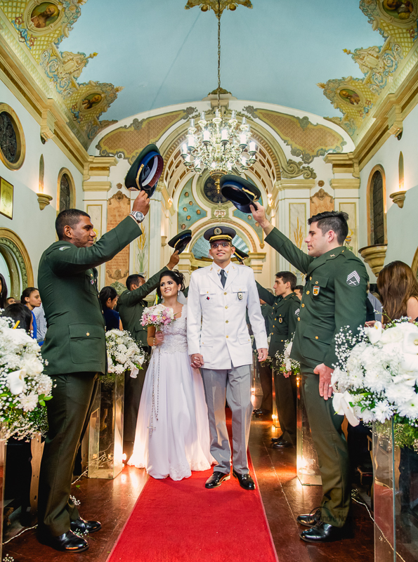 noiva e noivo de mãos dadas pelo corredor da igreja