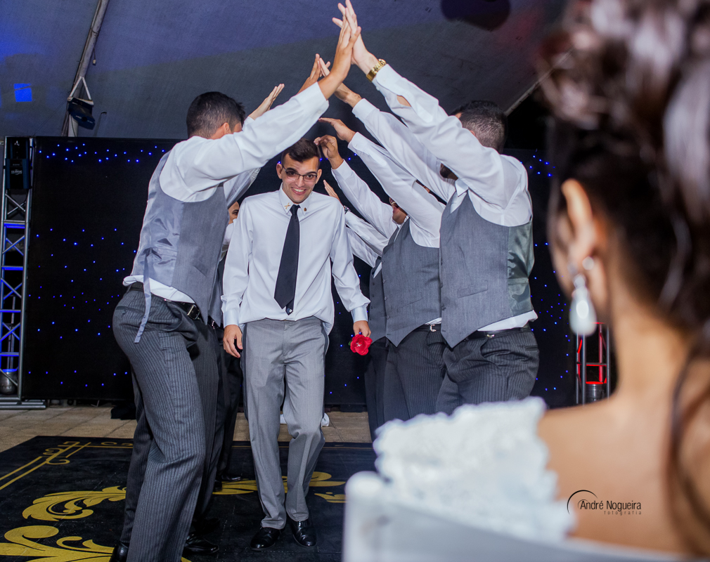 noivando passando pelo tunel formado pelos padrinhos, com uma rosa na mão