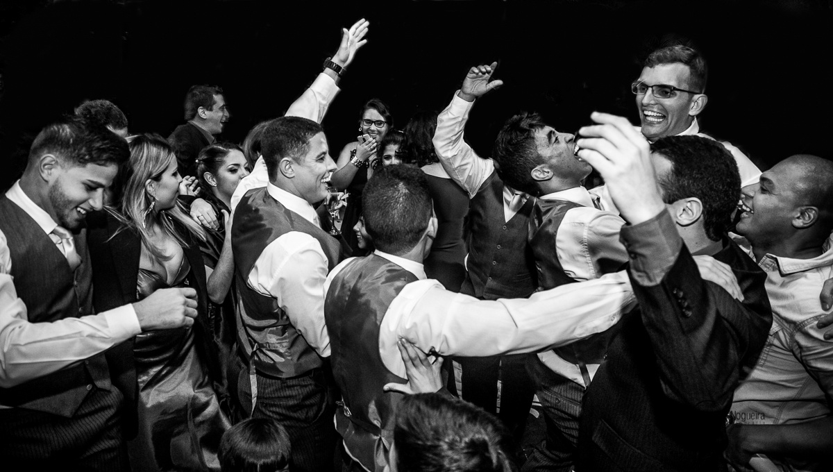 padrinhos abraçando o noivo na pista de dança