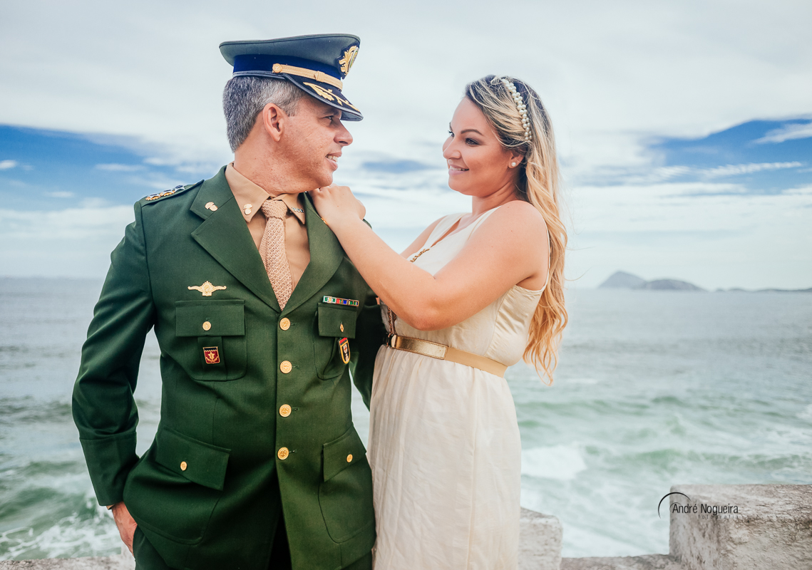 fotos do ensaio pre casamento rj, noiva apoiando as mãos nos ombros do noivos e olhando apaixonada pra ele no forte de copacabana