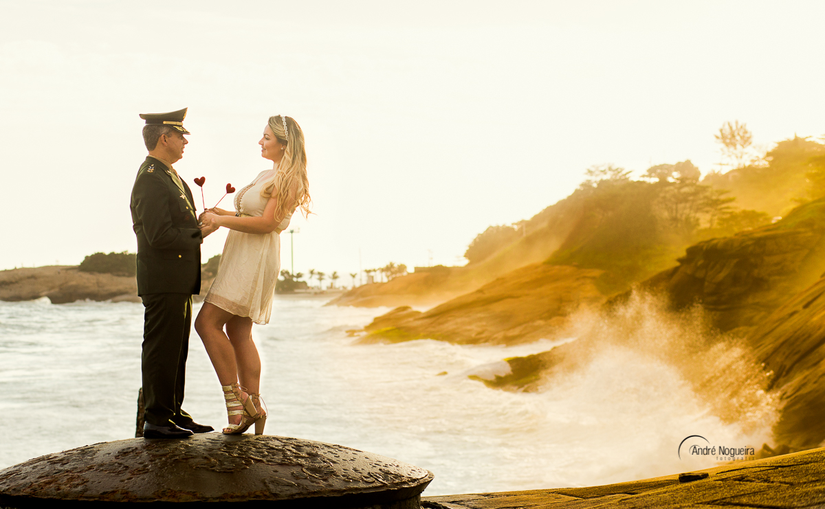 fotos ensaio noivos de mãos dadas durante o por do sol do forte de copacabana e com a bandeira do brasil ao fundo durante o pre casamento por andré nogueira fotografia