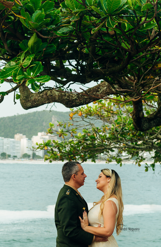 fotos de ensaio pre casamento, casal se olhando e abraçados em baixo da árvore do forte de copacabana por andre nogueira fotografia