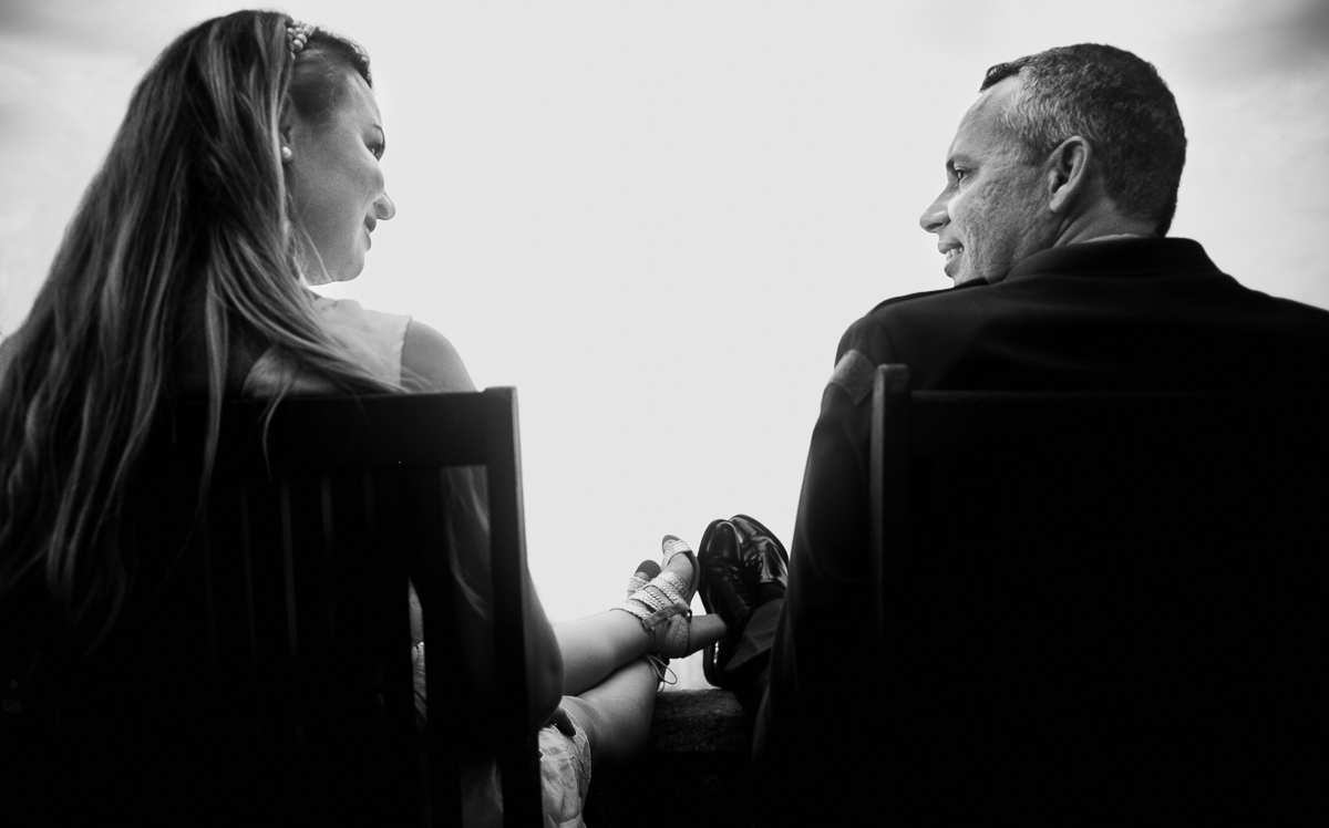 ensaio pre casamento rj, casal sentado na cadeira e com os pés na mureta do forte de copacabana por andre nogueira fotografia