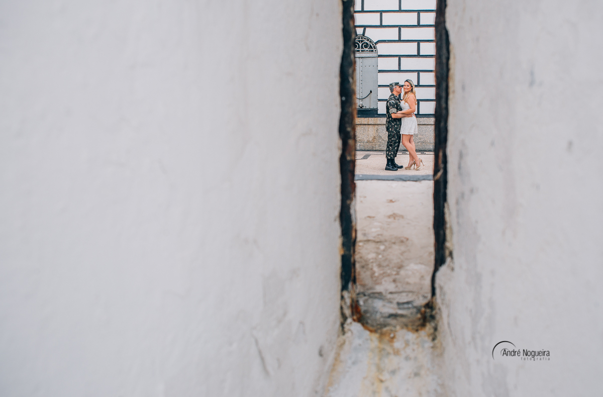 casamento rj,noivo beijando a encostado na parede, o casal se olham apaixonadosnoiva no forte de copacabana e ofotografo andre nogueira observa e fotografa
