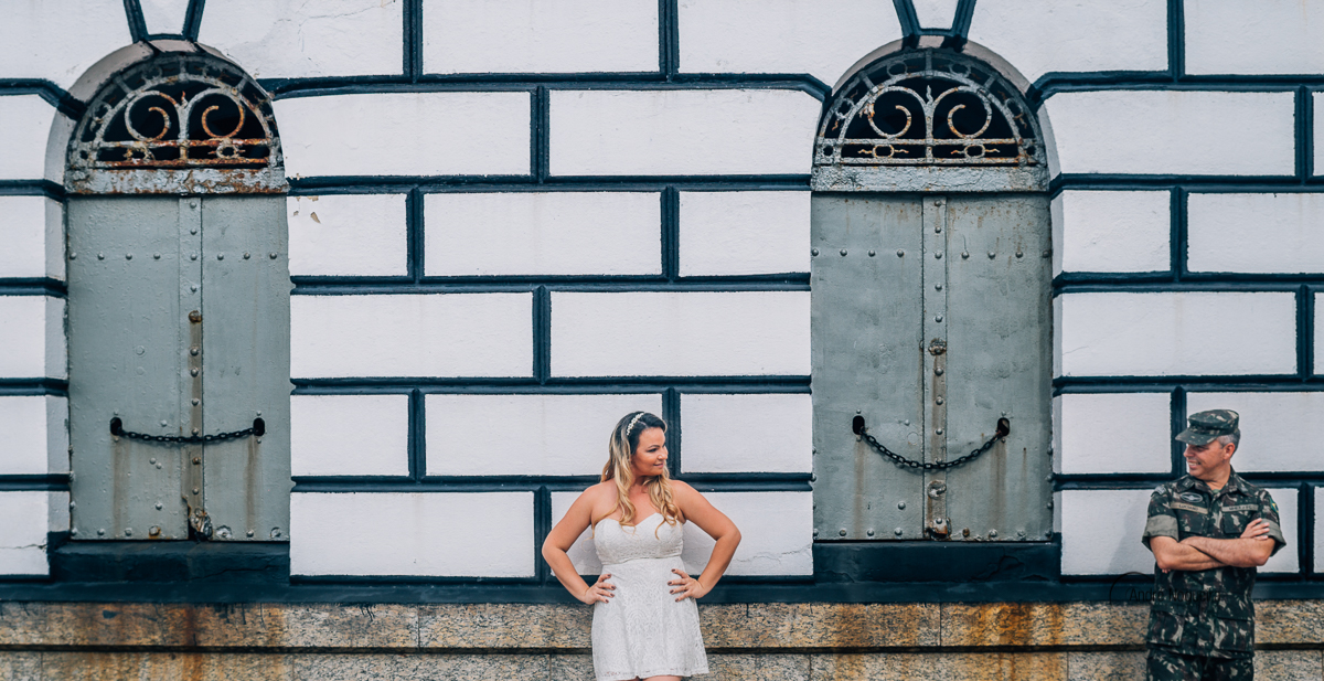 encostados na parede, os noivos se olham durante o ensaio pré-casamento no forte de copacabana, sendo fotografado pelo fotógrafo de casamento André nogueira fotografia