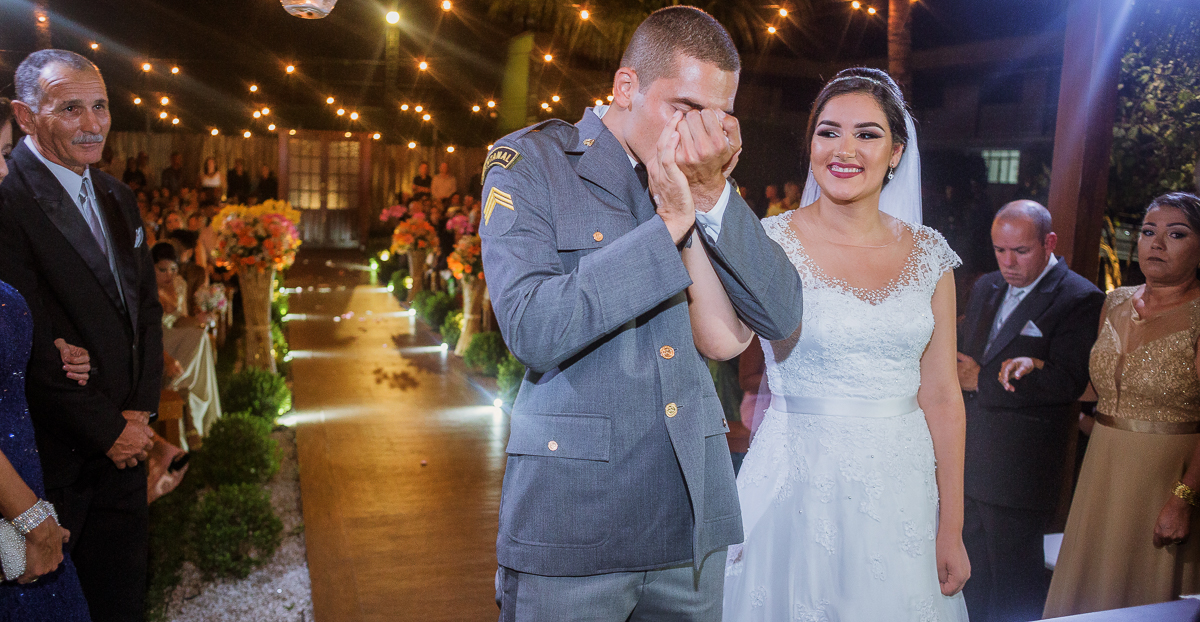 noivo beijando a mão da noiva e a noiva olhando apaixonadamente