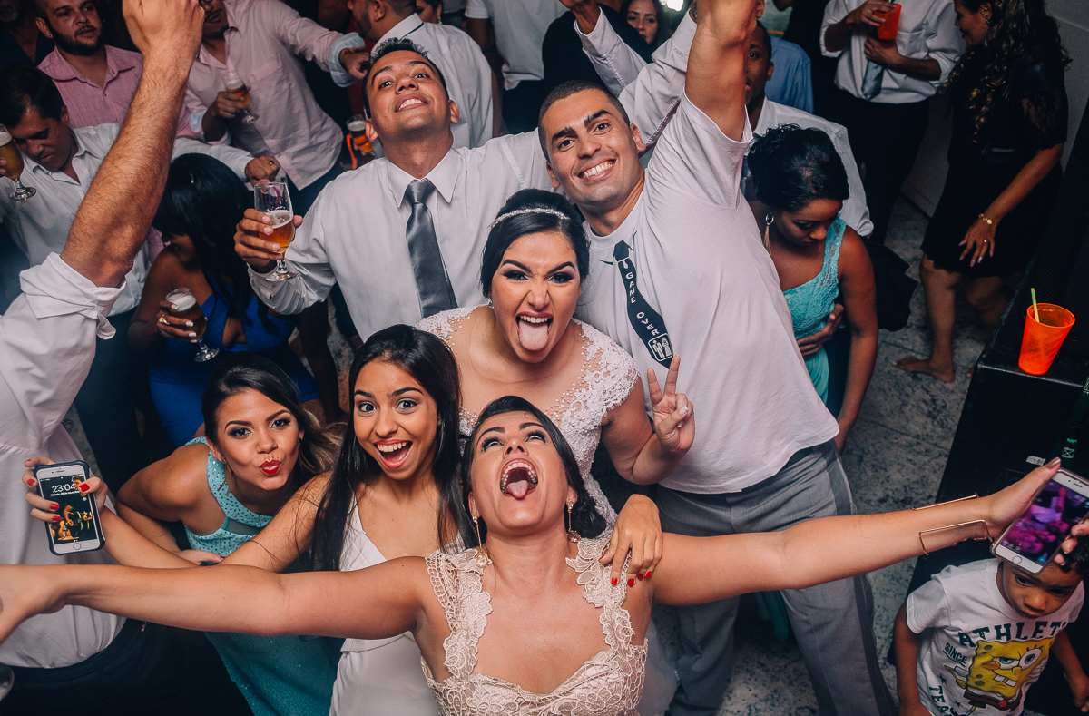 noivos fazendo self com a irmã e convidados