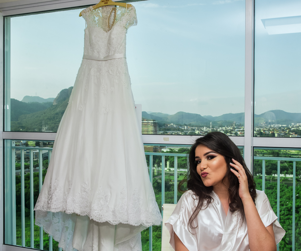 fotografo de casamento rj, noiva fazendo bico, com o vestido de noiva do atelier morena andrade ao fundo por andre nogueira fotografia