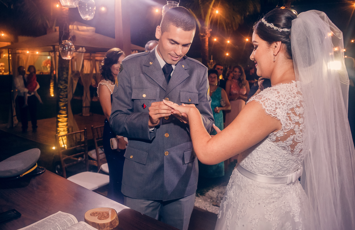 noivo colocando a aliança nas mãos da noiva