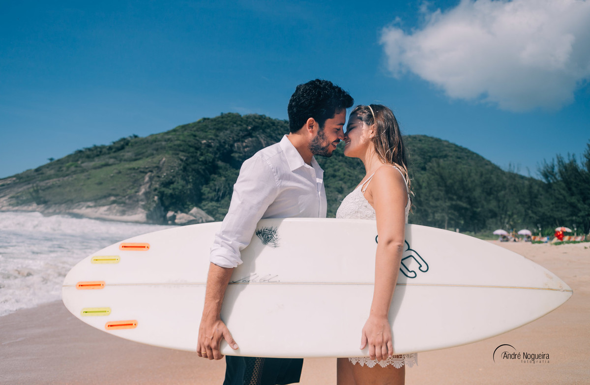 os dois estão segurando a prancha de surf e se beijando