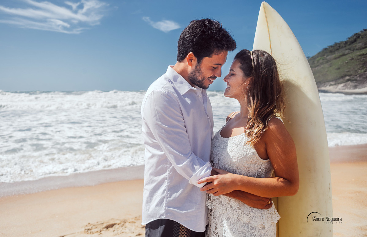 encostados na prancha de surf e se olhando e preparando para se beijarem