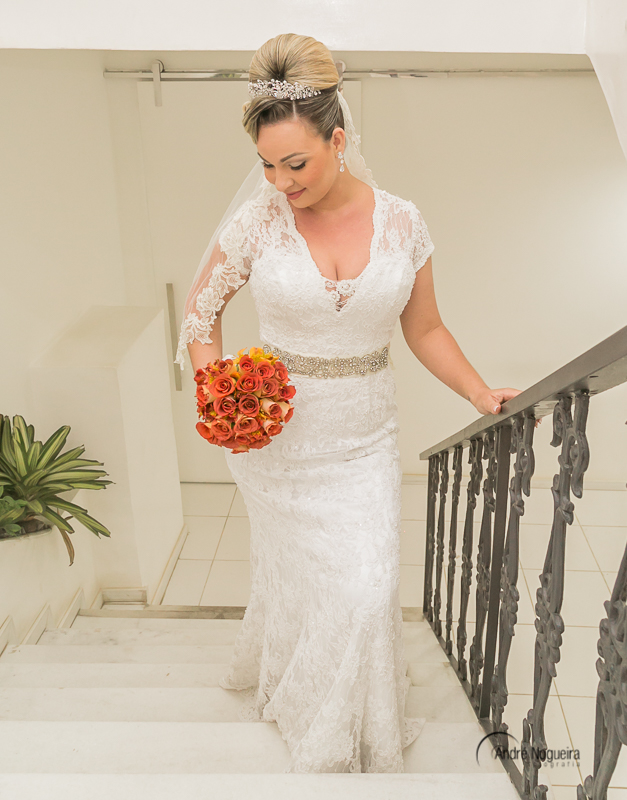 noiva subindo a escada e olhando para o seu lindo bouquet de flores na escadaria do salão de beleza Espaço Rio