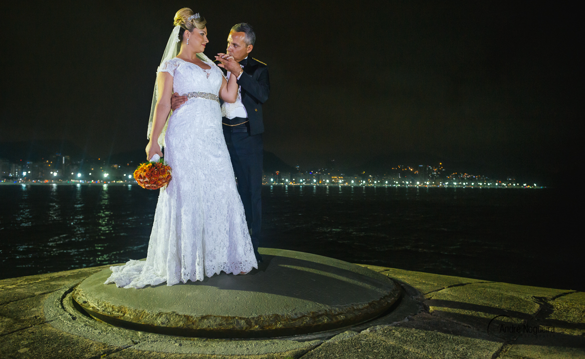 noiva tem a sua mão beijada e ao fundo temos a linda e tradicional praia de copacabana