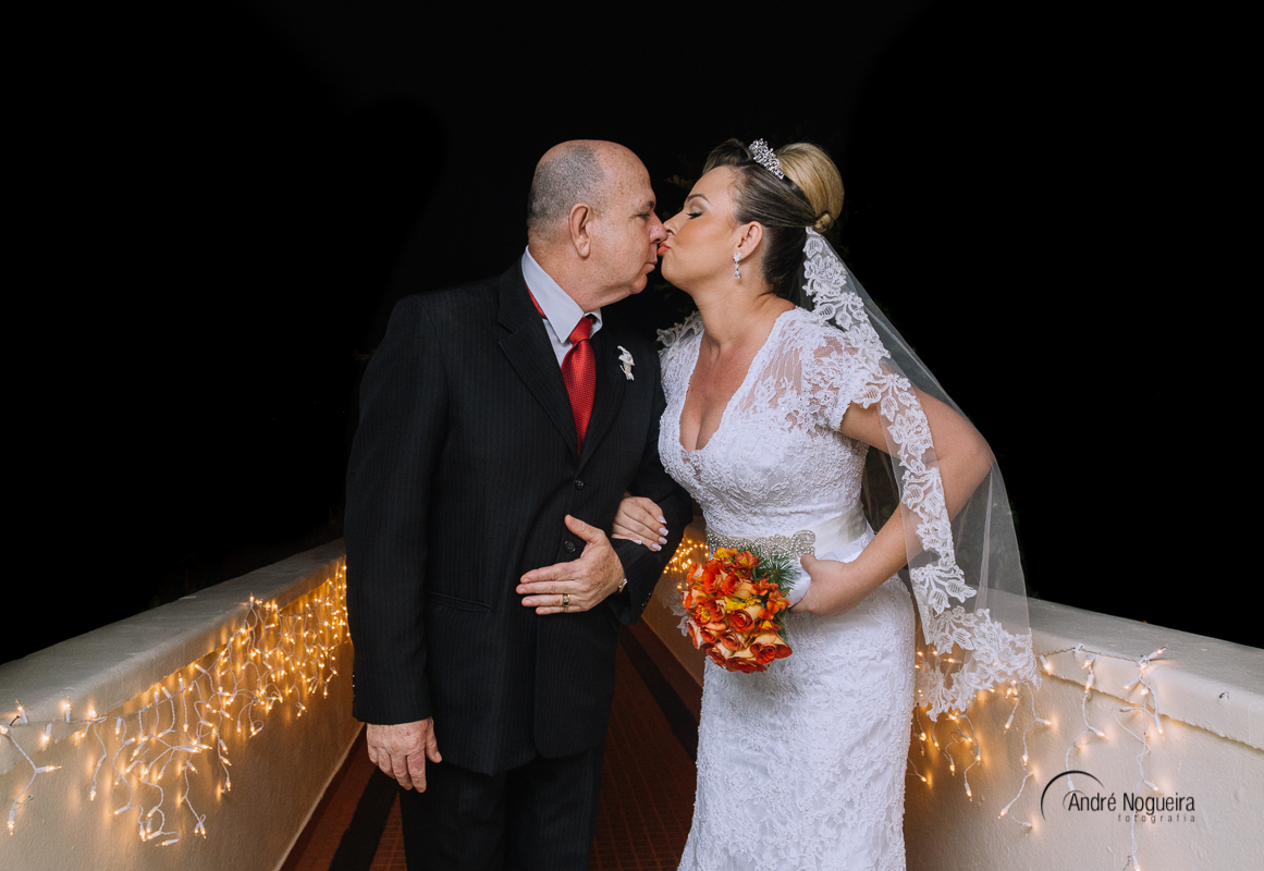 mãe da noiva segurando o espelho para mostrar a parte do cabelo para a noiva e madrinha