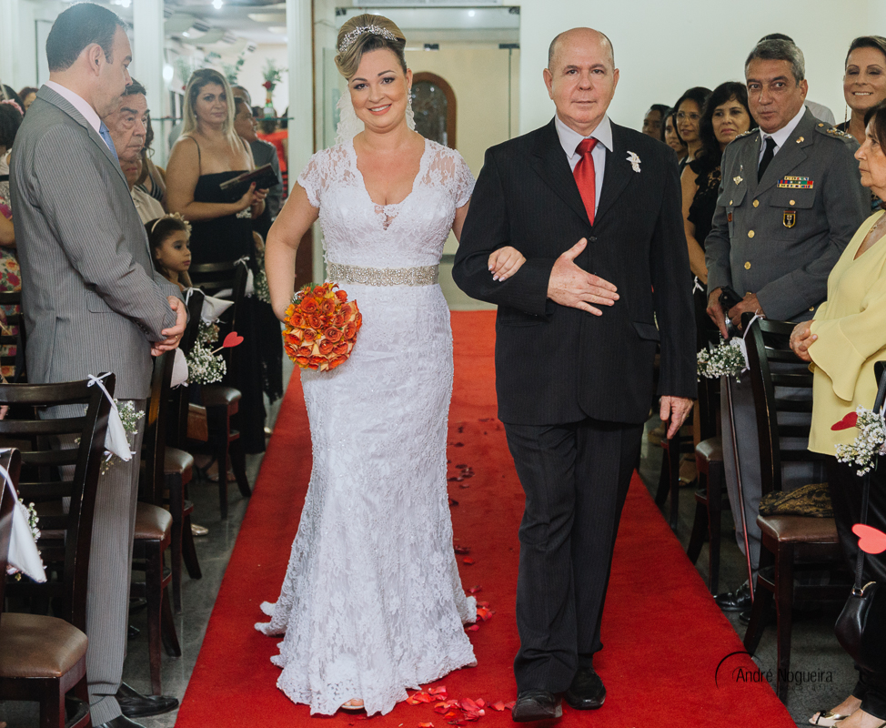 Filho dos noivos é ajudado pelo pai, pra arrumar o seu terno para o casamento