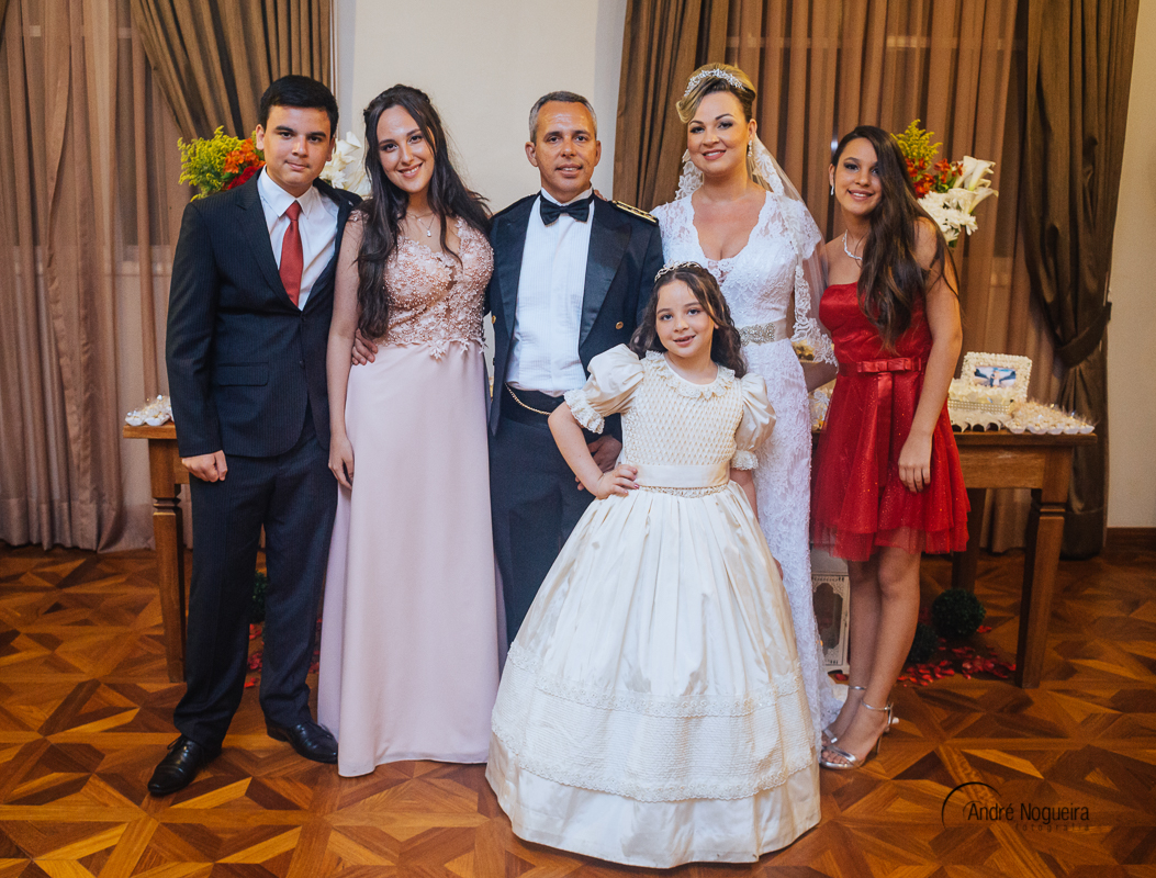 os noivos com os seus quatro filhos em frente a mesa do bolo do salão de festas do forte de copacabana