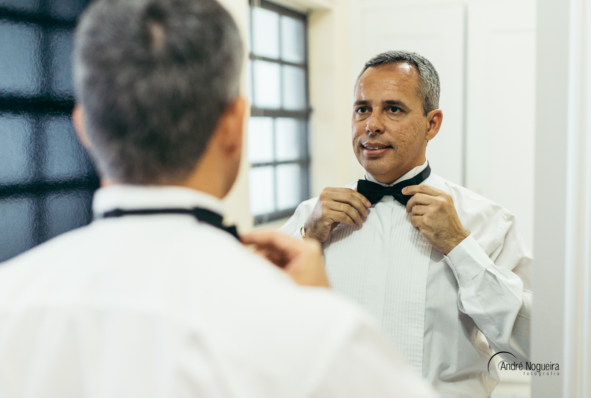 noivo ajustando a gravata em frente ao espelho