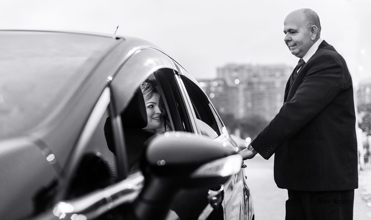 no forte de copacabana o pai da noiva abre a porta do carro, para sua filha noiva sair e ir rumo ao seu lindo casamento