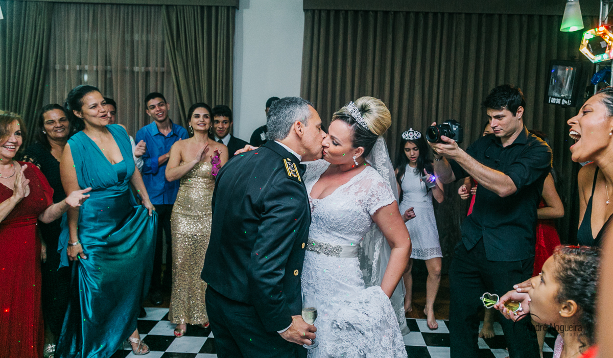 se beijando os noivos curtem a pista de dança com os convidados olhando atentamente