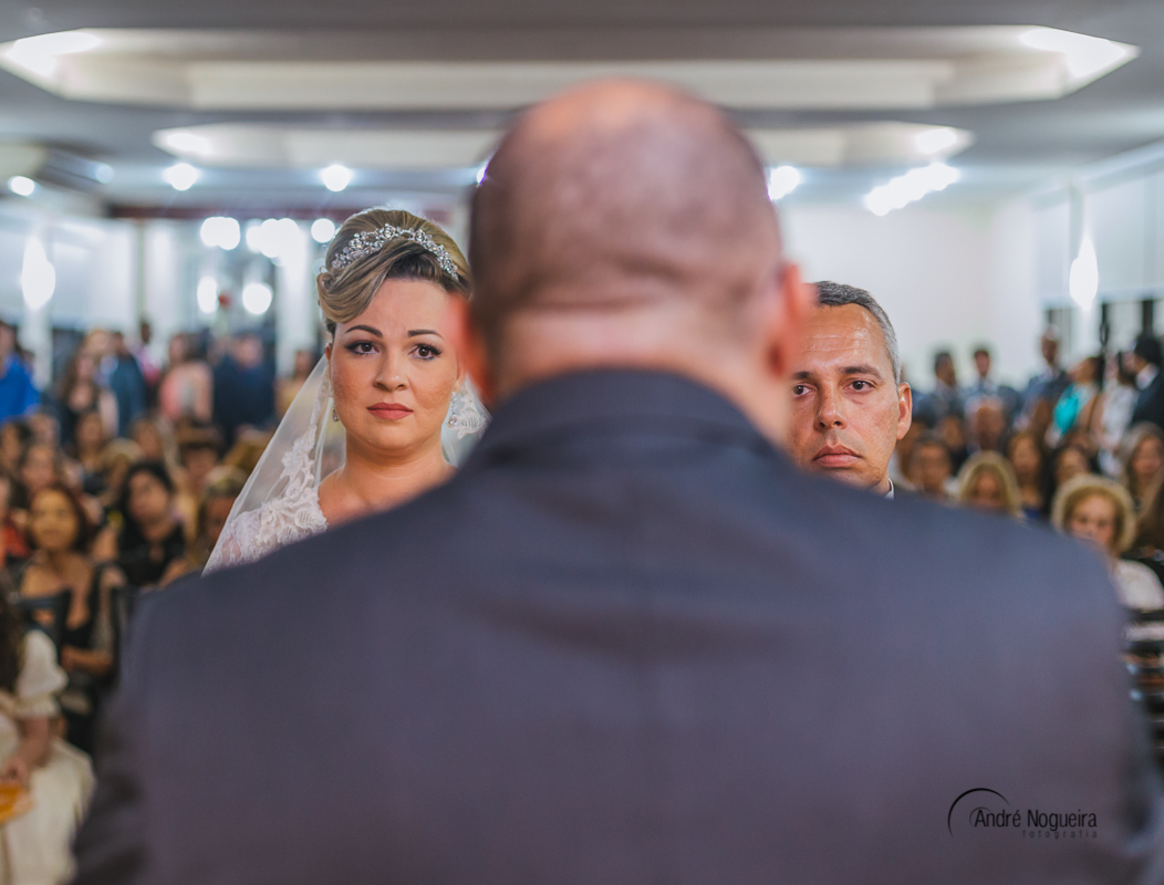 no lindo salão de cerimônia do forte de copacabana, num casamento lindo os noivos observam o pastor discursar