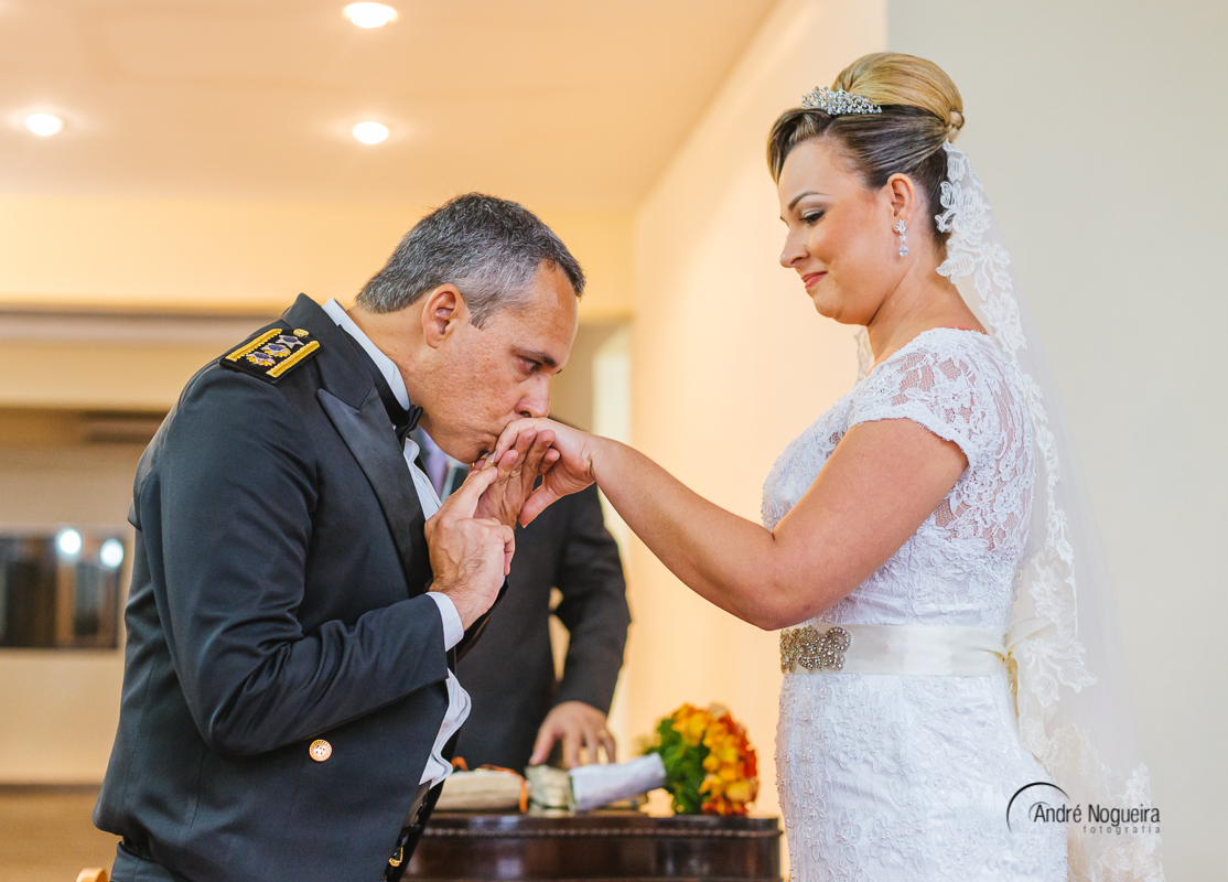 o fotografo andre nogueira fotografia registra uma linda cena nesse casamento emocionante. O noivo beijando a mão da noiva após ele colocar a aliança nas mãos da noiva que observa tudo emocionada