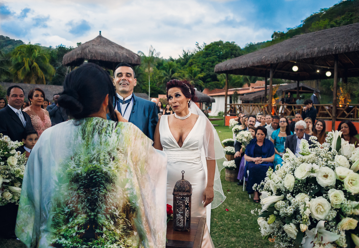 A juiz de paz diz ao engraçado para os noivos, que riem juntos com os convidados na chácara do sapê, registrado pelo andré nogueira fotografia