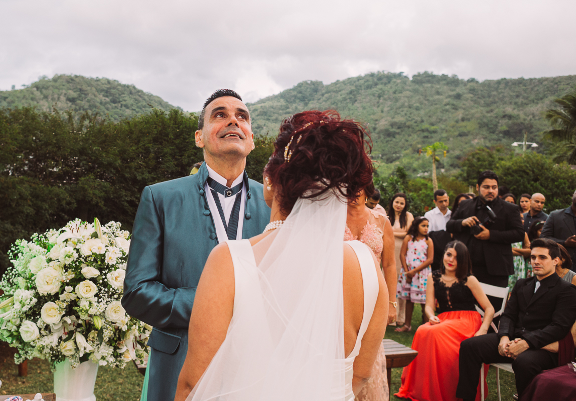 fotografo de casamento rj andré nogueira fotografia registra o momento que o noivo chora, durante a cerimônia realizada no gramado do sítio chácara do sapê