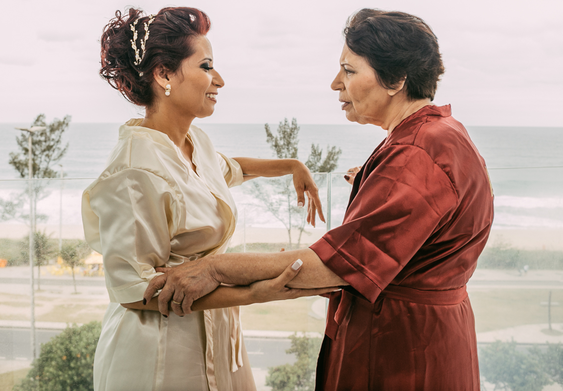 noivas rj, na sacada da varanda do hotel, a noiva e mãe se olham com o mar do recreio ao fundo por andré nogueira fotografia