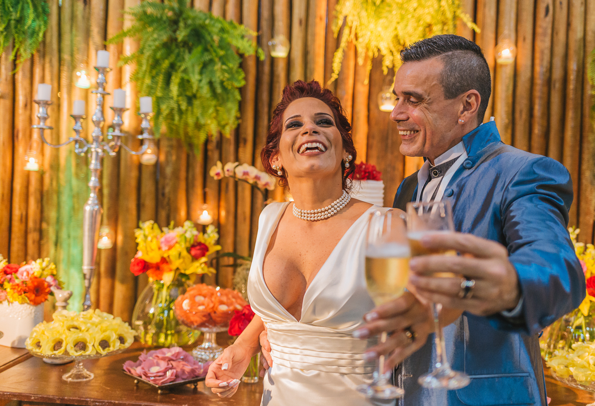 casamento rj,noiva sorrindo enquanto brinda com o seu noivo, em frente a mesa do bolo, chácara do sapê, casamento sergio e betania