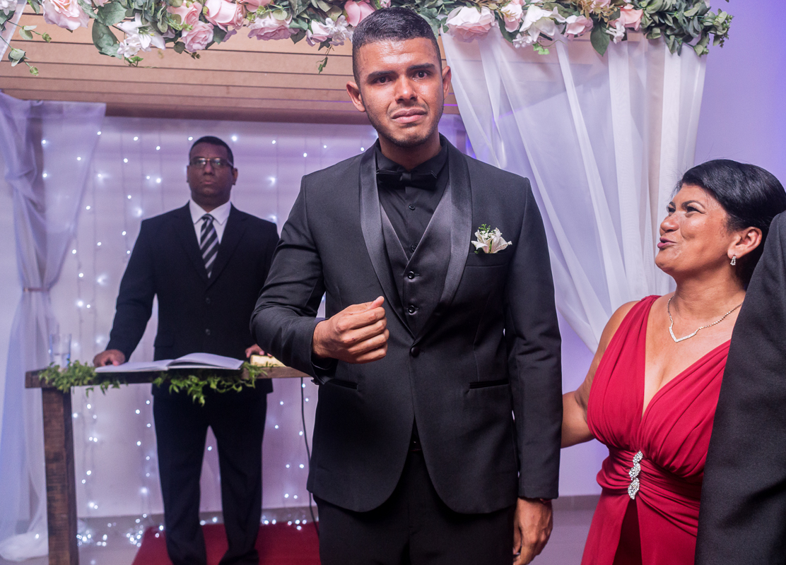 Casamento rj, mãe da noiva observa seu filho o noivo chorando, durante a entrada da noiva na cerimônia de casamento, batuli festas, fotografia por andre nogueira fotografia