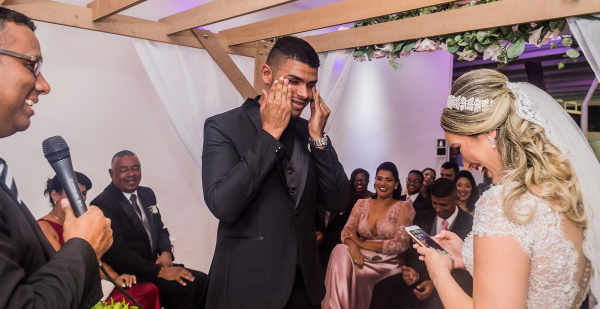 fotografia de casamento rj, noivo enxuga as lágrimas enquanto a noiva lê os votos, foto registrada por André Nogueira Fotografia, no salão de festa Batuli Festas nova iguaçu
