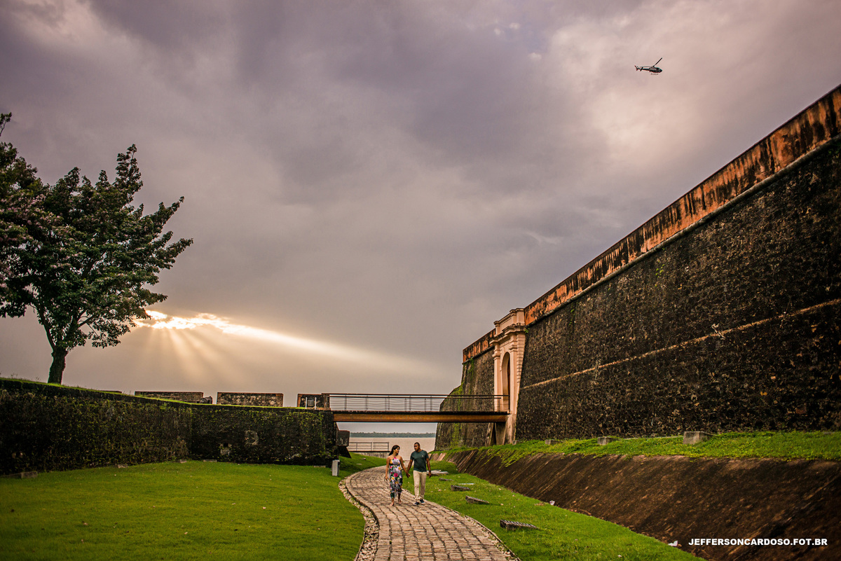 Ensaio casal feliz bem romântico em belém PA no forte do presépio com muito amor e sorrisos fotos feita pelo melhor fotografo de casamento Jefferson Cardoso fotografia book de Dani e William final de tarde com pôr do sol e chuva e árvores de ipê rosa