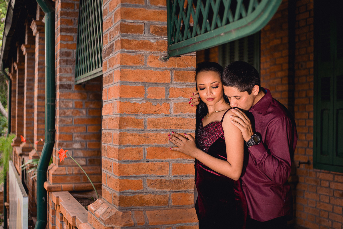 noivo beijando o ombro da noiva no dia do ensaio pré wedding e a noiva com vertido da cor marsala 