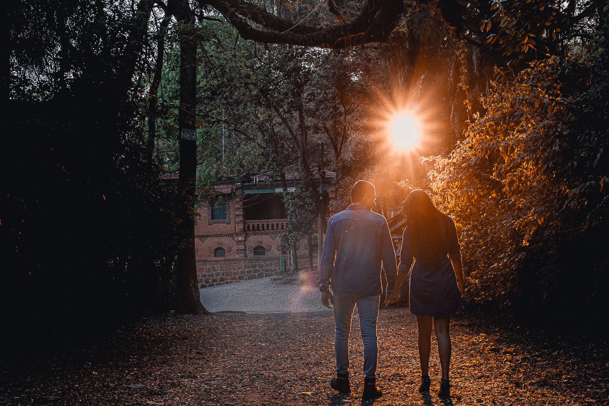 foto dos noivo caminhando e olhando um para o outro noivo beijando o ombro da noiva no dia do ensaio pré wedding e a noiva com vertido da cor marsala
