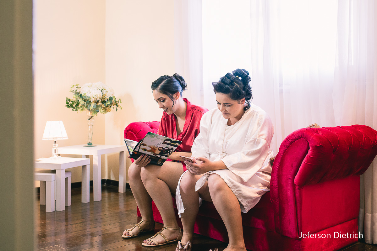 noiva sentada em um sofa vermelho mexendo no celular sansung em fotografo de casamento - sp, fotografo de casamento campinas - spfotografo de casamento – sp , fotografo de casamento campinas – sp , fotografo de casamento americana – sp , fotografo - sp