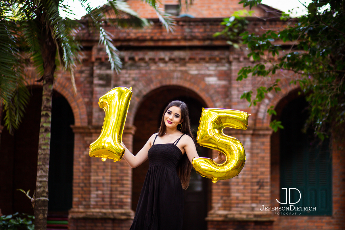 Fotografia da debutante com o numero 15 na mão