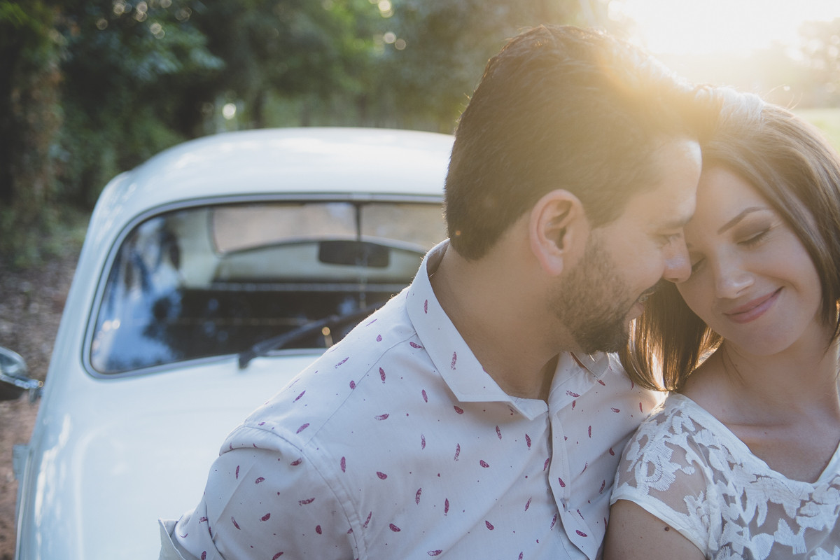 casal em momento de carinho com um fusca e por do sol