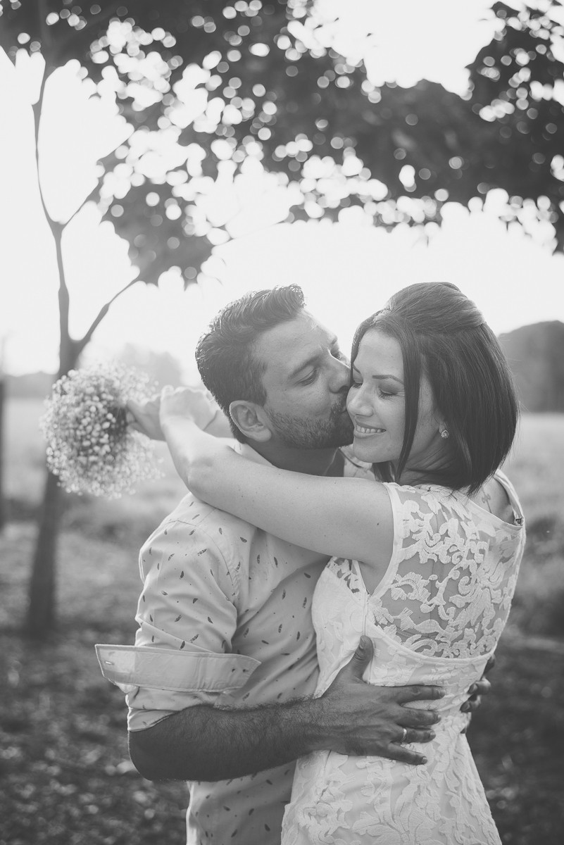 noivo beijando a noiva em local aberto