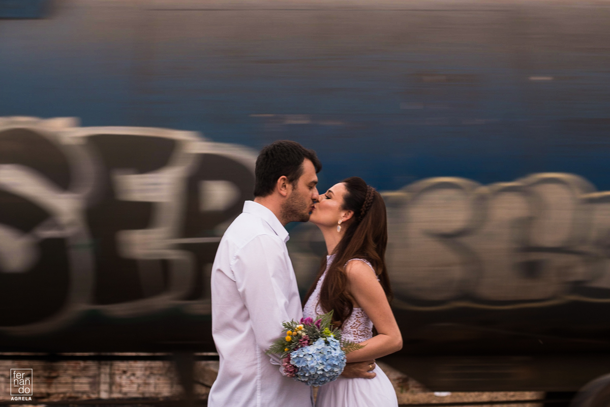 casal se beijando com trem passando ao findo