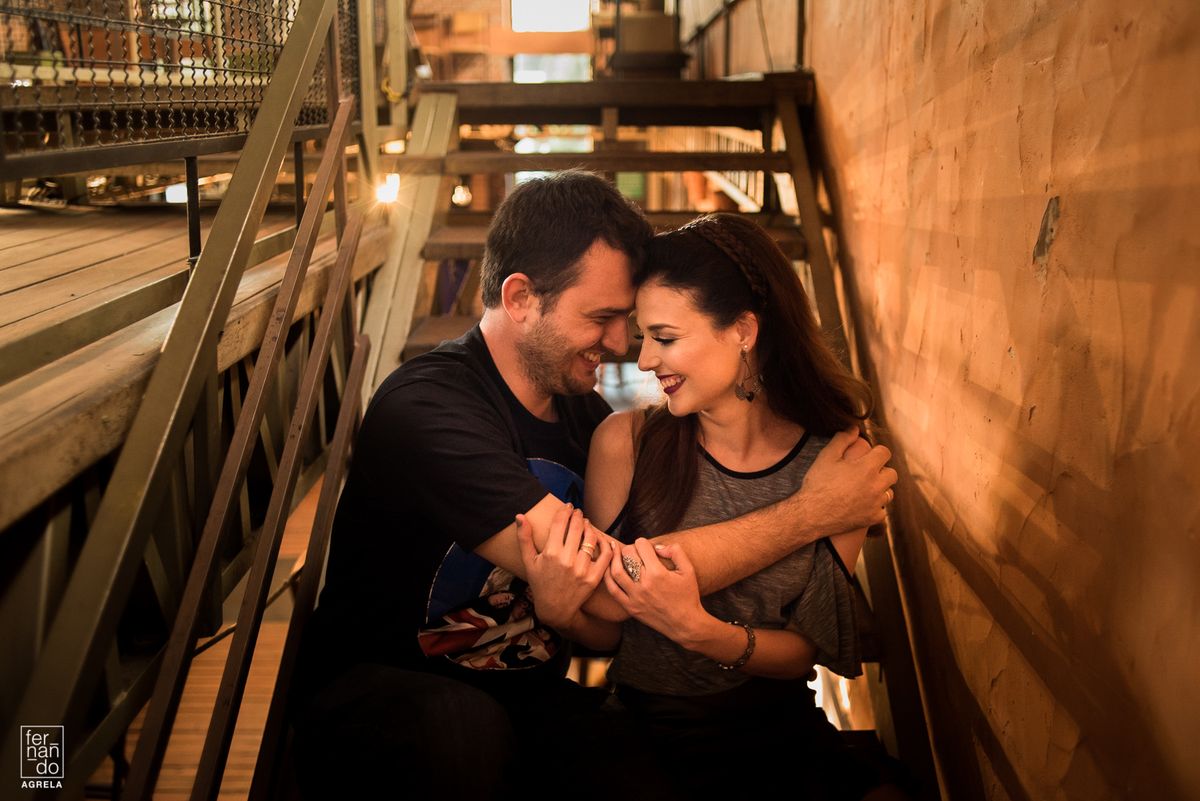 casal abraçado sorrindo em uma escadas 
