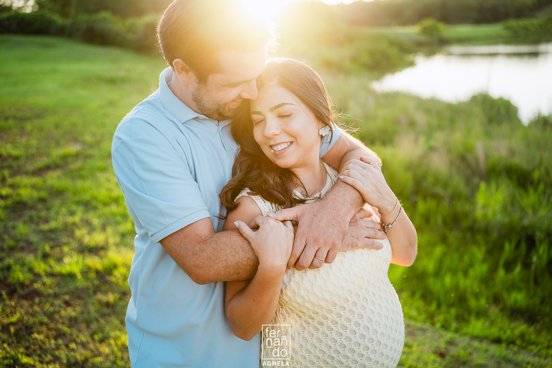 casal em ensaio de gestação ao ar livre com o por do sol ao fundo