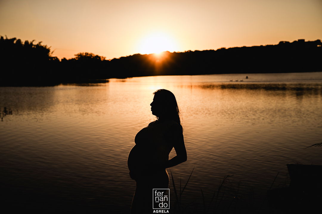 silhueta de mulher gestante com um lago ao fundo