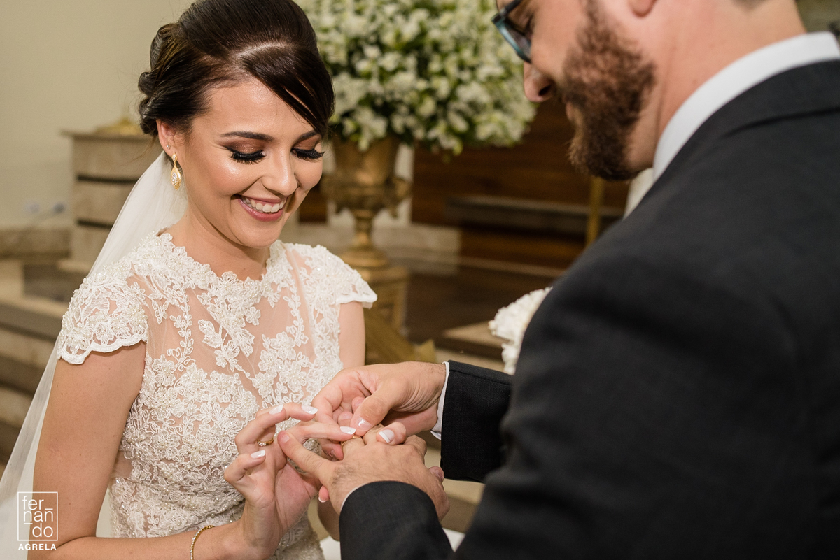 noiva colando aliança no noivo durante a cerimonia de casamento