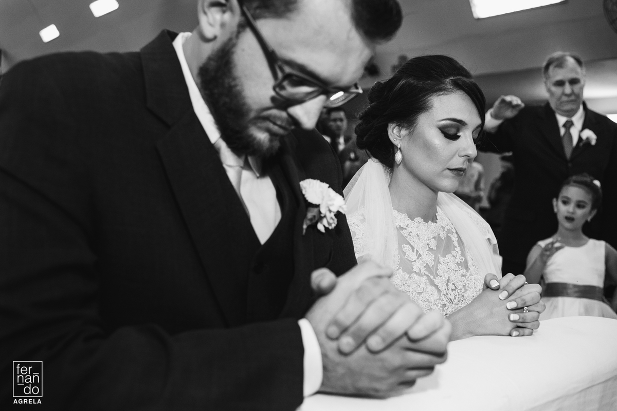 noivos em momento de oração durante a cerimonia